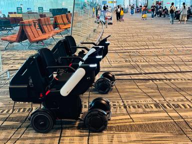 Mehrere autonom fahrende WHILL Rollstühle des WHILL Autonomous Service im Transitbereich des Flughafens Changi.